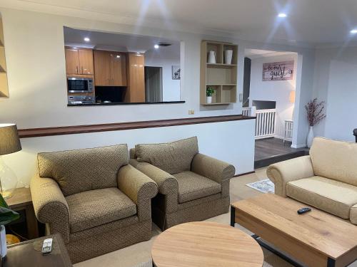 a living room with two chairs and a table at Luxury Lake Front Living in Lake Albert