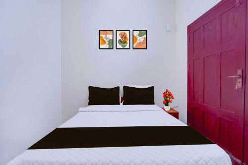 Un dormitorio con una cama grande con una puerta roja. en Hotel O Kunchithanny Road Munnar, en Munnar