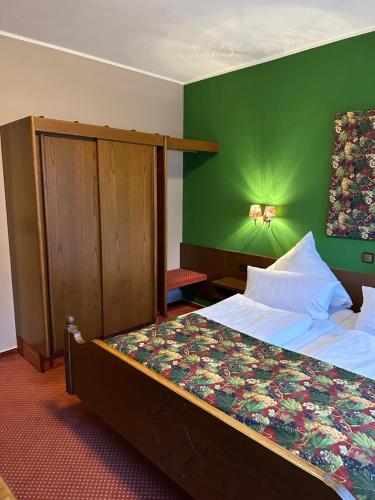a bedroom with a bed with a green wall at Lesura Ferien- Apartment in Lieser