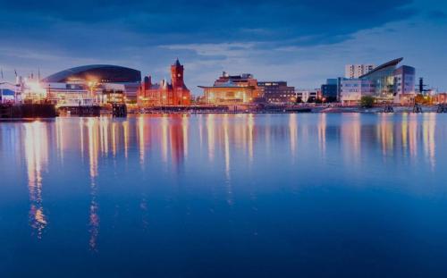 a view of a city from the water at night at City centre apartment 2 in Cardiff