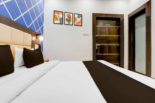a bedroom with a large white bed and a closet at Hotel O Khajuraho Central in Khajurāho
