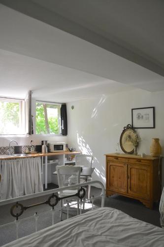 a bedroom with a bed and a table and a kitchen at la maison in Libourne