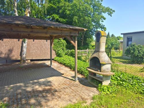a outdoor oven is sitting in a yard at Fischstübchen Neeberg Fewo 4 – Schwalbennest in Krummin