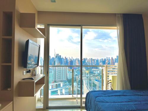 a bedroom with a large window with a view of a city at Super City View Room, Swimming Pool,Gym,150m walk to BTS in Bangkok