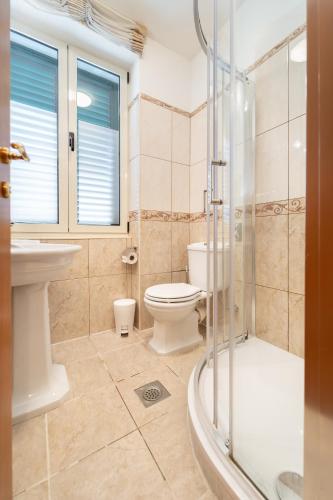 a bathroom with a toilet and a sink and a shower at Hotel Peristil in Split