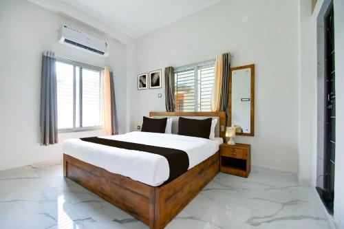 a bedroom with a large bed and a mirror at Hotel O VIP Road Near Golden Beach in Puri