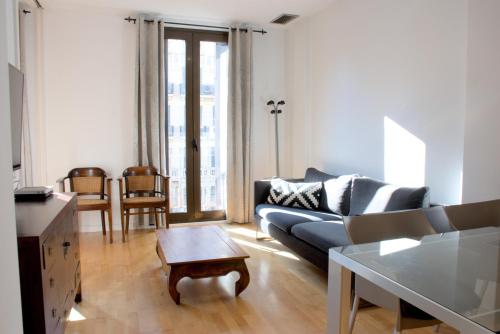 a living room with a couch and a table at SWEET BCN Rambla 48 in Barcelona