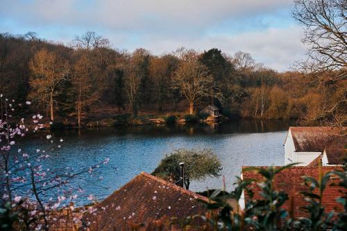 a view of a lake with a house and trees at Crafted at Powdermills in Battle