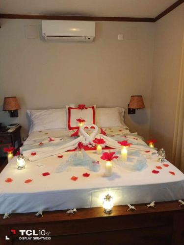 a bed with candles and flowers on top of it at Hôtel Blue Bay Madagascar in Amborovy