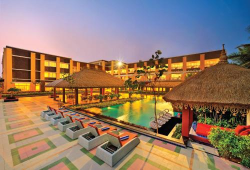 a resort with a pool and chairs and a building at Mayfair Waves in Puri