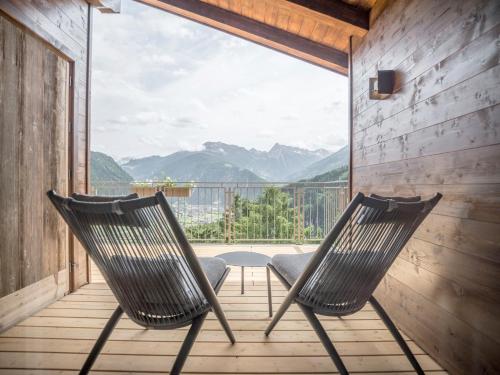 two chairs on a porch with a view of mountains at die Aussicht in Finkenberg