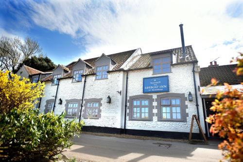 a white building with a blue sign on it at The Lifeboat Inn in Hunstanton