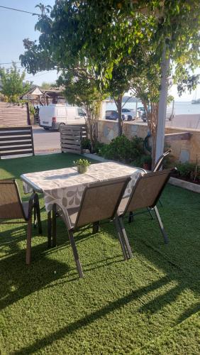 a table and two chairs sitting on the grass at Galazio suites 1 in Salamís