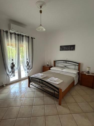 ein Schlafzimmer mit einem Bett und einem großen Fenster in der Unterkunft Villa Facen Stella in Liapades