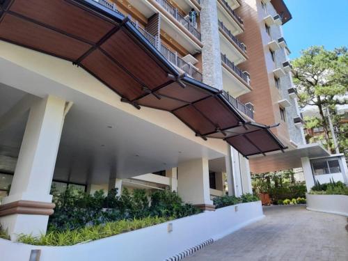 an apartment building with a balcony on the side at Brenthill Condo Baguio 1BR Mountain & SM View in Baguio