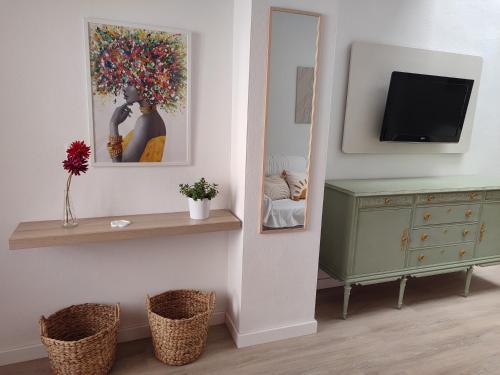 a room with a mirror and a dresser and a tv at Luz de Calma in Tabernas