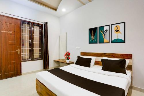a bedroom with a large bed and a wooden door at Collection O Bareilly Near Satellite Bus Stand in Bareilly