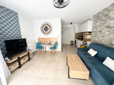 un salon avec un canapé bleu et une table dans l'établissement Chez Candie, à La Trinité