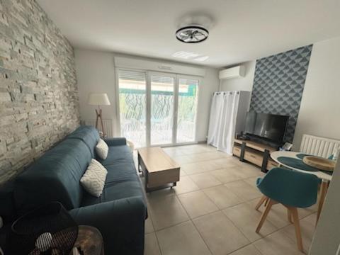 un salon avec un canapé bleu et une table dans l'établissement Chez Candie, à La Trinité