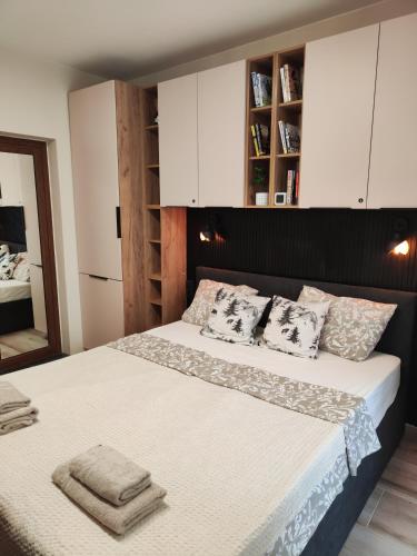 a bedroom with a large bed with white cabinets at Студио Sand, к-с Нестинарка in Tsarevo