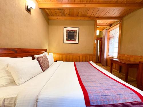 a bedroom with a large white bed in a room at Shivadya - A Luxury Boutique Experience in Manāli
