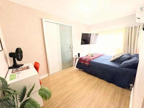 a bedroom with a bed with a blue bedspread at Apê Refúgio Urbano in Brasilia