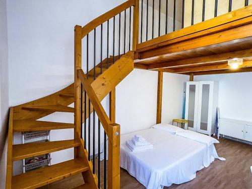 een slaapkamer met een wit bed en een houten trap bij Centralissimo a Gaeta - CasAurora P2 in Gaeta