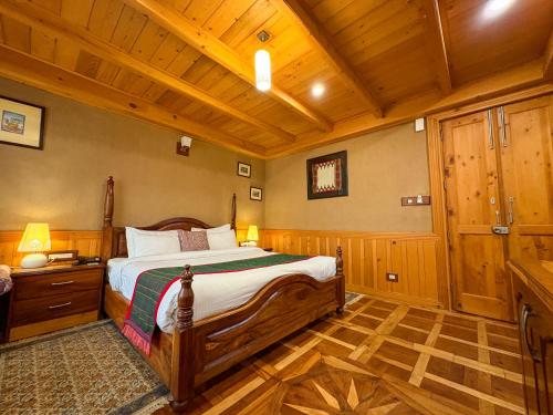 a bedroom with a bed and a wooden ceiling at Shivadya - A Luxury Boutique Experience in Manāli