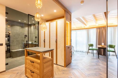 a bathroom with a walk in shower and a sink at Mirabell Dolomites Hotel - Luxury Ayurveda & Spa in Valdaora