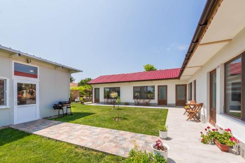 a backyard of a home with a patio at Sea Breeze Vacation House I BBQ & Jacuzzi in Ezerets