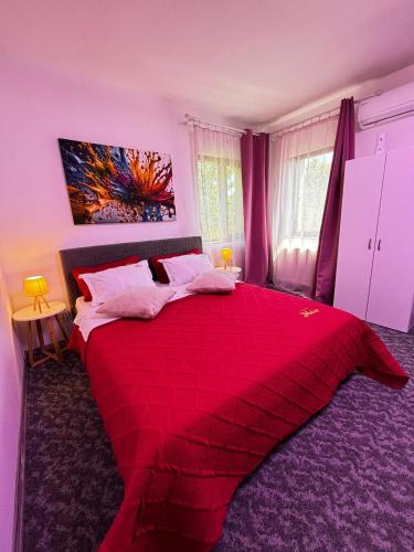 a bedroom with a red bed with a red blanket at Muller Residence in Timişoara