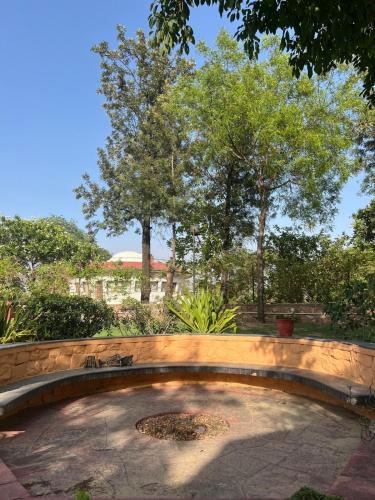 a stone patio with trees in the background at Mati by Jain Farms in Sohna