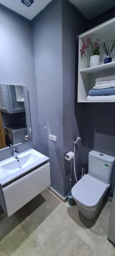 a bathroom with a white toilet and a sink at Mansouria beach resort in Mohammedia
