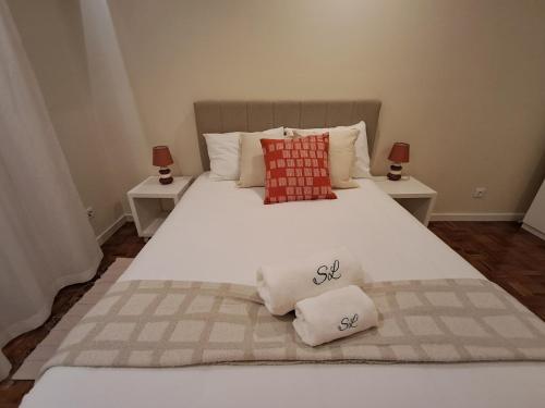 a bedroom with a large white bed with two tables at Sweet Living Lisboa in Lisbon