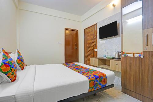 a bedroom with a bed and a television in it at FabHotel Tarini Comforts - Marathahalli in Bengaluru