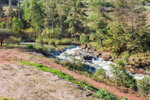 a river in the middle of a dirt road at The River Boutique Inn in Lobamba