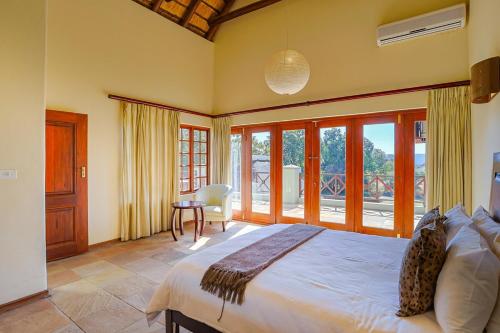 a bedroom with a large bed and a large window at Stunning Bushveld Villa 84 in Warmbaths