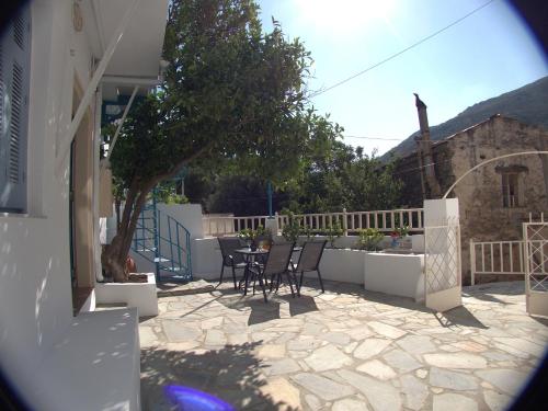 a patio with chairs and a tree on a house at Polidoros vintage house 13 km from Elafonisi in Vathi