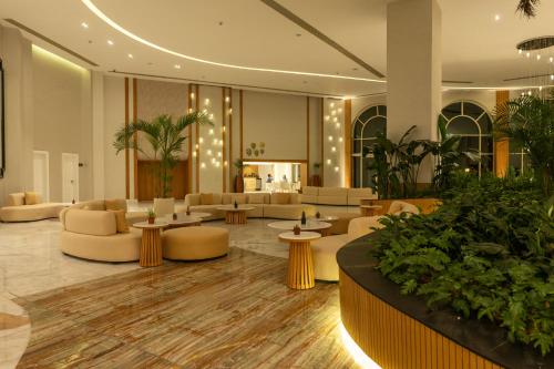 a lobby with couches and tables and plants at Cleopatra Sidi Heneish in Marsa Matruh