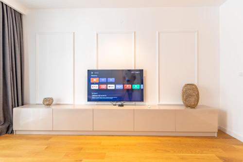 a tv sitting on a white cabinet in a living room at Park Vila Apartments in Belgrade