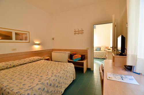 a hotel room with a bed and a table and a television at Hotel Aurora in Sperlonga