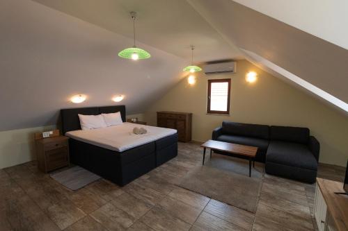 a bedroom with a bed and a couch in a attic at Rooms by the sea Sutivan, Brac - 24402 in Sutivan
