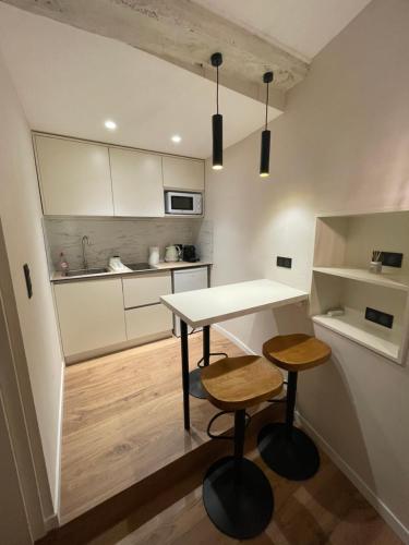 - une petite cuisine avec une table et deux tabourets dans l'établissement Refurbished apartment in the Old Town, steps from the beach, à Menton