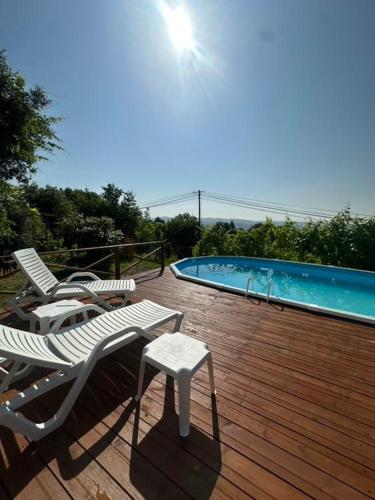 a deck with two chairs and a swimming pool at Casa Das Vendas in Vendas