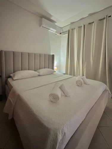 a bedroom with a white bed with towels on it at Larissa city ap 7 with parking in Larisa