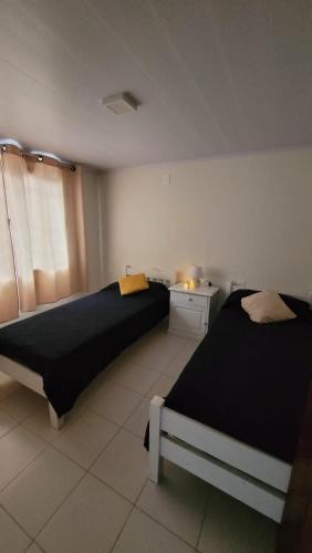 a bedroom with two beds and a window at Casa completa con muchas comodidades in Paysandú