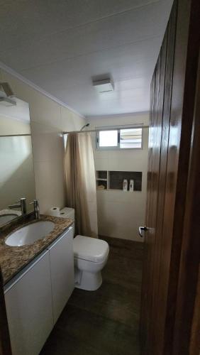 a bathroom with a toilet and a sink at Casa completa con muchas comodidades in Paysandú
