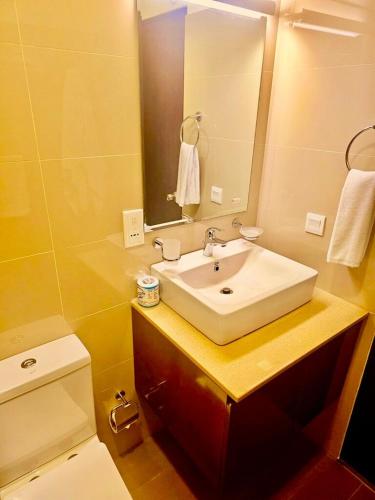 a bathroom with a sink and a mirror and a toilet at Ocean Breeze Pearl in Negombo
