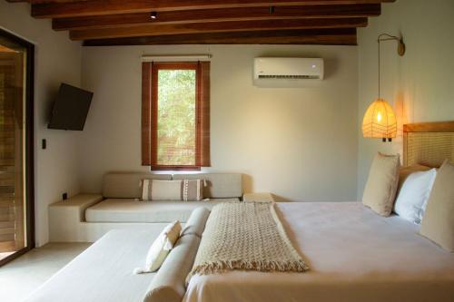 a bedroom with two beds and a window at ICACO refugio de playa in Guachaca