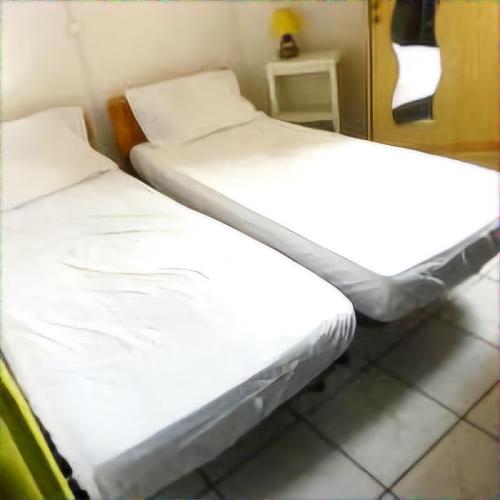 deux lits dans une chambre avec des draps blancs dans l'établissement Mimi, à Port-la-Nouvelle